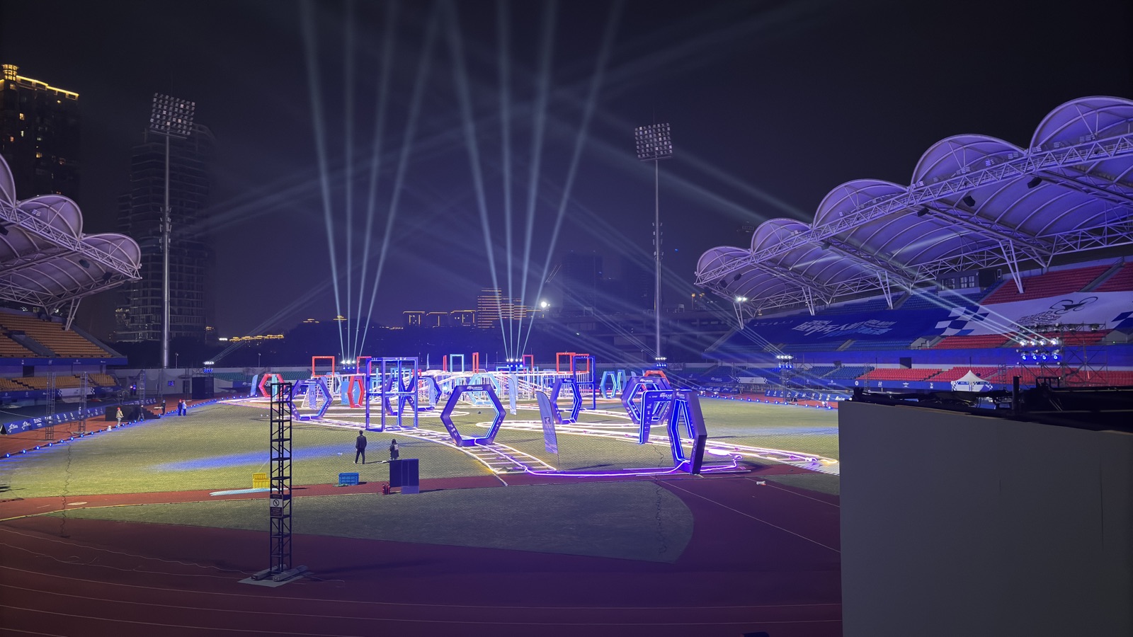 The lit WDRC 2024 race track in a stadium at night.